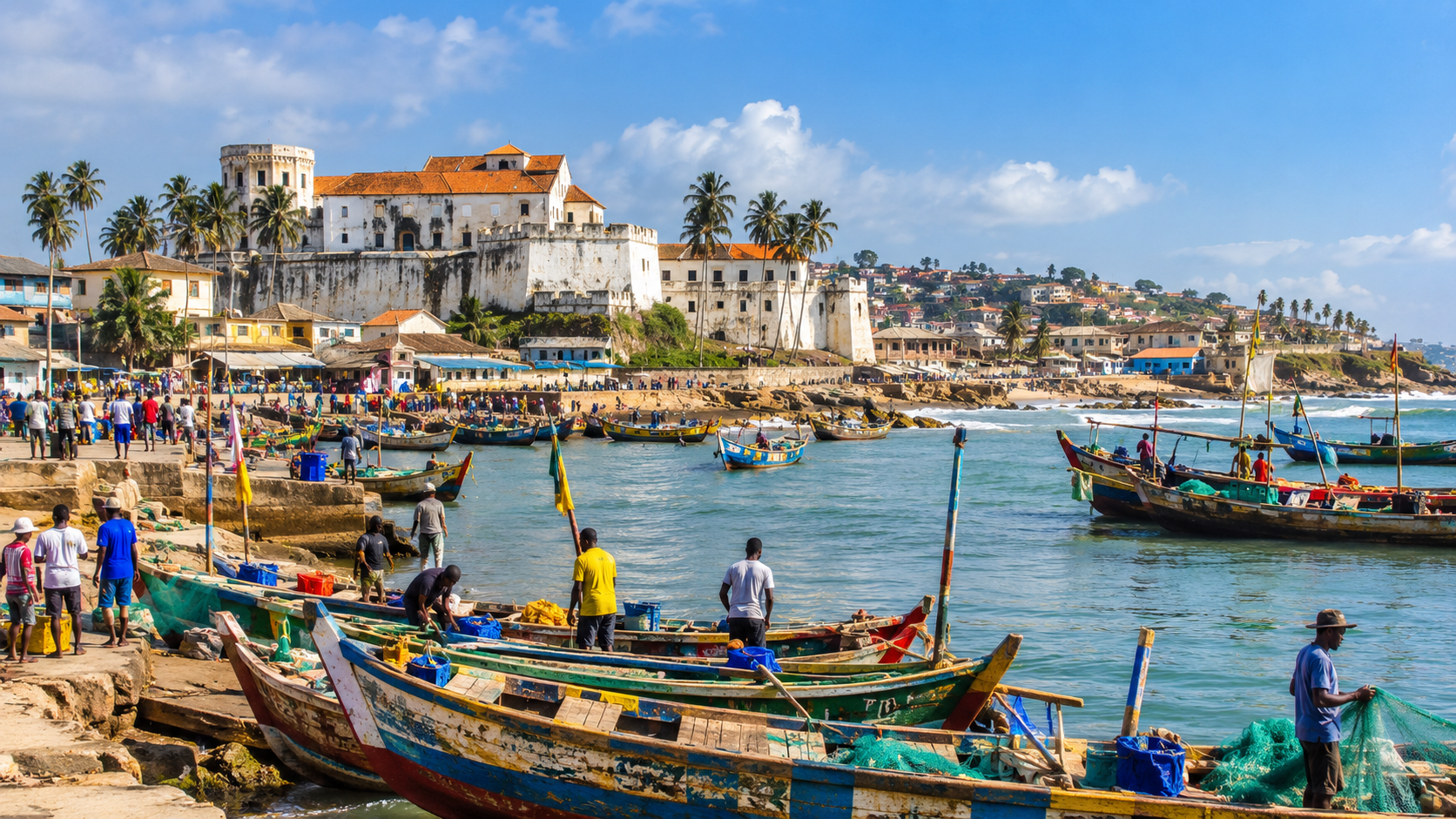 Elmina, Ghana, historic coastal town with colorful fishing boats, busy waterfront, palm trees, and historic architecture under a bright blue sky.